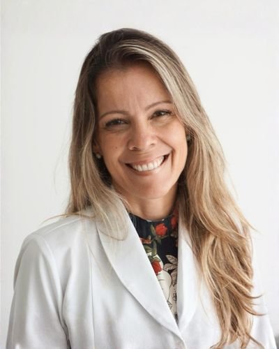 Dra. Cristiane Alves de Oliveira, médica obstetra e professora universitária, sorridente em ambiente clínico